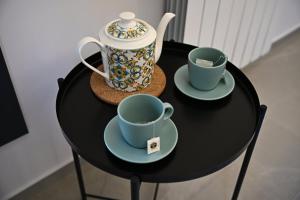 two cups and saucers on a black table at Kleos Luxury Rooms in Porto Empedocle