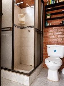 a bathroom with a toilet and a glass shower at Apartaestudio amoblado in Jamundí