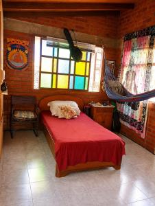 a bedroom with a red bed and a window at Apartaestudio amoblado in Jamundí