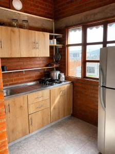 a kitchen with wooden cabinets and a stainless steel refrigerator at Apartaestudio amoblado in Jamundí