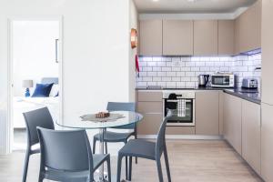 a kitchen with a table and chairs in a room at City Stay Apartments - Platform Bedford in Bedford