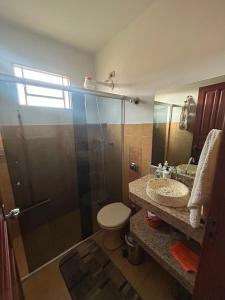 a bathroom with a shower and a toilet and a sink at Casa da Conceição in Capitólio
