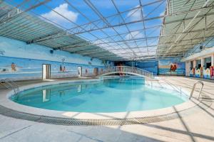 a large indoor swimming pool with a glass ceiling at Hotel O Star Inn in Hyderabad