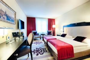 a hotel room with a large bed and a desk at Welcome Hotel Residenzschloss Bamberg in Bamberg