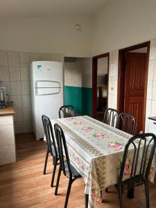 a kitchen with a table with chairs and a refrigerator at Casa da Conceição in Capitólio