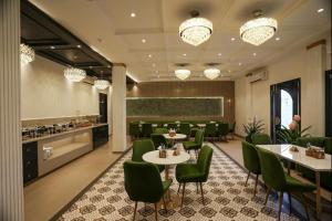 a dining room with tables and green chairs at The ELET near Amritsar Airport in Amritsar