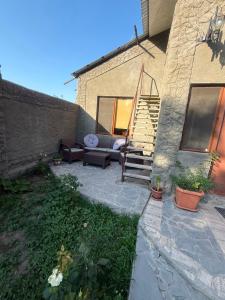 a patio with a couch and stairs next to a building at home 4 room in Yerevan
