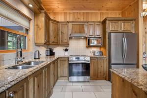 a kitchen with wooden cabinets and a stainless steel refrigerator at Fiddler Lake Resort - Deer 48 in Mille-Isles
