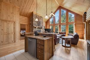 a kitchen and living room in a log cabin at Fiddler Lake Resort - Deer 48 in Mille-Isles