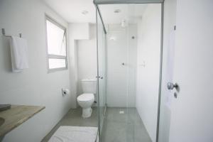 a bathroom with a toilet and a glass shower at CLH Suites Domingos Ferreira in Rio de Janeiro +42 photos