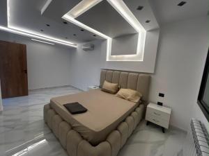 a large bed in a white room with a ceiling at Villa zhara in Bizerte