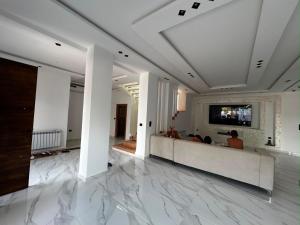 a lobby with white walls and a television on a wall at Villa zhara in Bizerte +12 photos