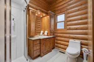 a bathroom with wooden walls and a toilet and a sink at Fiddler Lake Resort - Deer 48 in Mille-Isles +23 photos