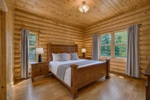 a bedroom with a bed in a log cabin at Fiddler Lake Resort - Deer 48 in Mille-Isles
