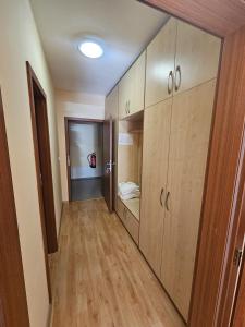 a hallway with wooden cabinets and a bed in a room at Pokojíček 512 in Lázně Luhačovice