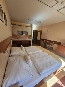 a large white bed in a room with a kitchen at Pokojíček 512 in Lázně Luhačovice
