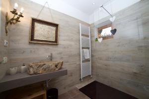 a bathroom with a sink and a wooden wall at A&B Le Terrazze del Sale' - Apartments in Trento