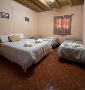 a room with two beds with towels on them at EL AMANECER hospedaje y excursiones in El Peñón