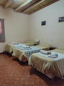 a room with three beds in a room at EL AMANECER hospedaje y excursiones in El Peñón +4 photos