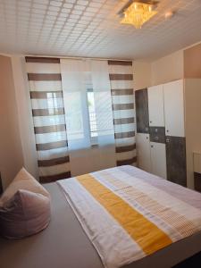 a bedroom with a large bed and two windows at Marina in Bleckede