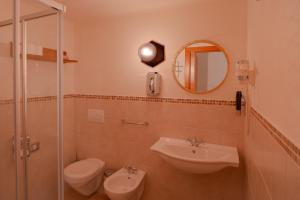 a bathroom with a sink and a toilet and a mirror at Planat in San Cassiano