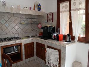 a kitchen with a sink and a counter with a microwave at I Due Ciuchini Sardinia in Sassari +24 photos