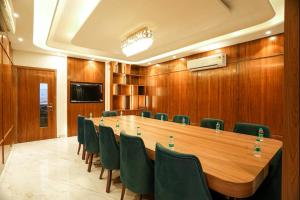 a conference room with a long table and green chairs at The ELET near Amritsar Airport in Amritsar +52 photos