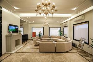 a large living room with couches and a chandelier at The ELET near Amritsar Airport in Amritsar