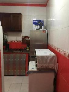 a kitchen with a counter with a refrigerator in it at Superbé appartement bien équipé, situé à environ 300 Mètres de la plage Martil in Martil