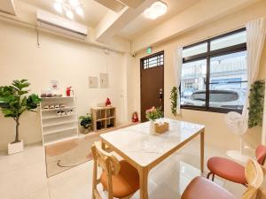 a living room with a table and some chairs at 哈樓民宿二館 in Lukang