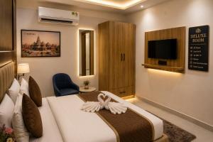 a hotel room with a bed and a tv at Hotel Aarambh By Ramayana Grand-Near Ram Mandir Ayodhya in Ayodhya