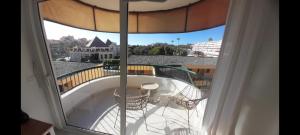 a balcony with a table and a large window at TORRES DEL SOL A 50 metros playa las vistas in Playa de las Americas