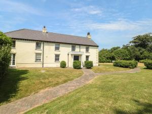 a large white house with a driveway at Clynnog House in Dwyran