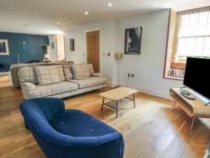 a living room with a couch and a table at Clynnog House in Dwyran