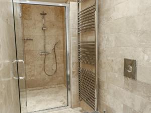 a shower with a glass door in a bathroom at Clynnog House in Dwyran +29 photos