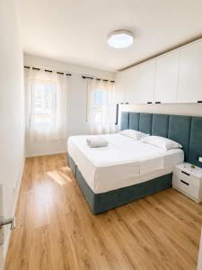 a bedroom with a large bed and wooden floors at Green Terrace Square View in Tirana