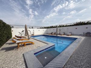 a swimming pool with chairs and umbrellas on a building at El Bawaba Lodge & Luxury Retreat in Luxor