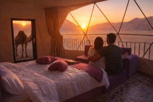a man and a woman sitting on a bed in a room at Wadi rum bubble camp in Wadi Musa +37 photos