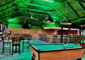 a pool table in a room with chairs and a bar at Ngandu Hotel - Rundu in Rundu