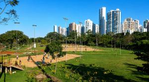a park in front of a city with tall buildings at Casa do Lago in Londrina