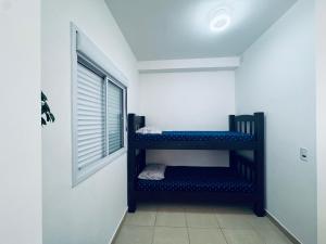 a room with two bunk beds in a room with a window at Apto frente o mar com 3 piscinas Wi-Fi gratuito aceito pet in Mongaguá +77 photos