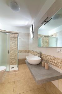 a bathroom with a large white sink and a shower at Poseidonia nel Borgo in Pulsano +10 photos