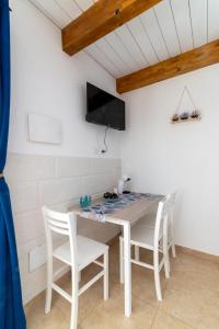 a white table and chairs in a room with a tv at Poseidonia nel Borgo in Pulsano