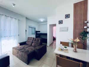 a living room with a couch and a table at Apto frente o mar com 3 piscinas Wi-Fi gratuito aceito pet in Mongaguá