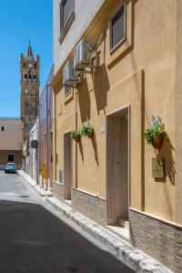 a building with potted plants on the side of a street at Poseidonia nel Borgo in Pulsano