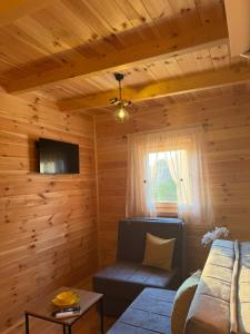 a living room with wooden walls and a couch at Bukuria e Fjerinës in Ulcinj