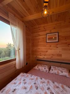 a bedroom with a bed in a log cabin at Bukuria e Fjerinës in Ulcinj