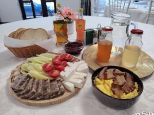 a table with a plate of food with meats and cheese at Casa AIDA in Peşteana