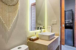 a bathroom with a sink and a toilet and a mirror at Villa 34 I Puerto Aventuras I Private Pool in Puerto Aventuras
