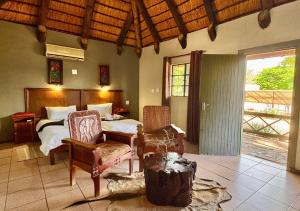 a bedroom with a bed and a table and chairs at Ngandu Hotel - Rundu in Rundu